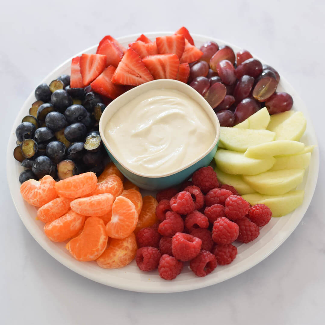 Fruit Platter & Maple Yogurt Dip: strawberries, grapes, apple, raspberries, clementines and blueberries on a platter with a small bowl of maple yoghurt dip in the centre