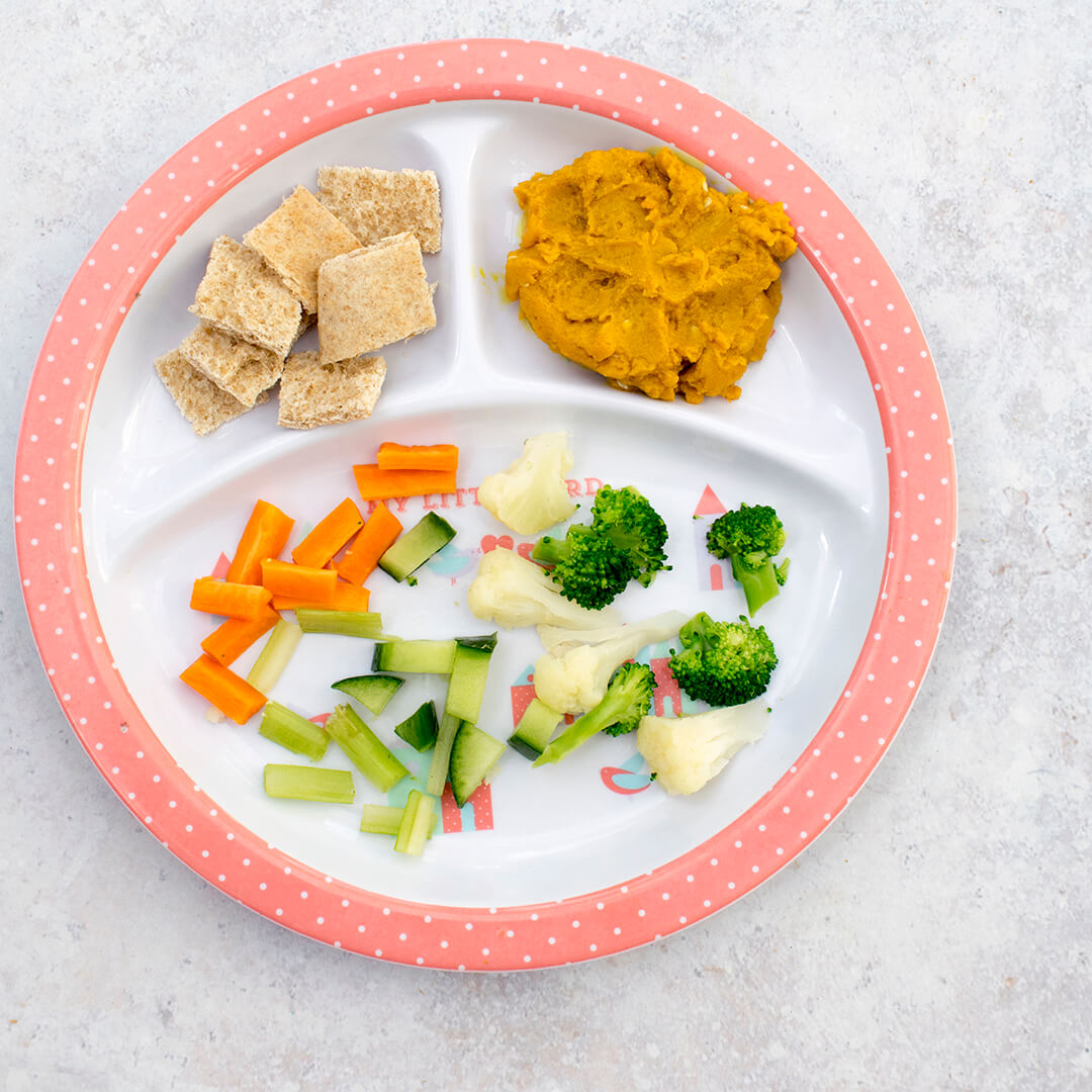 A plate of Sweet Potato & Turmeric Dip, broccoli, cauliflower, cucumber, carrots and bread