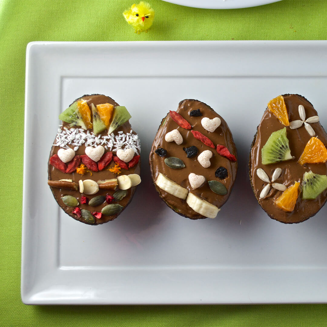 3 Avocado & Chocolate Orange Easter Eggs decorated with fruit and seeds