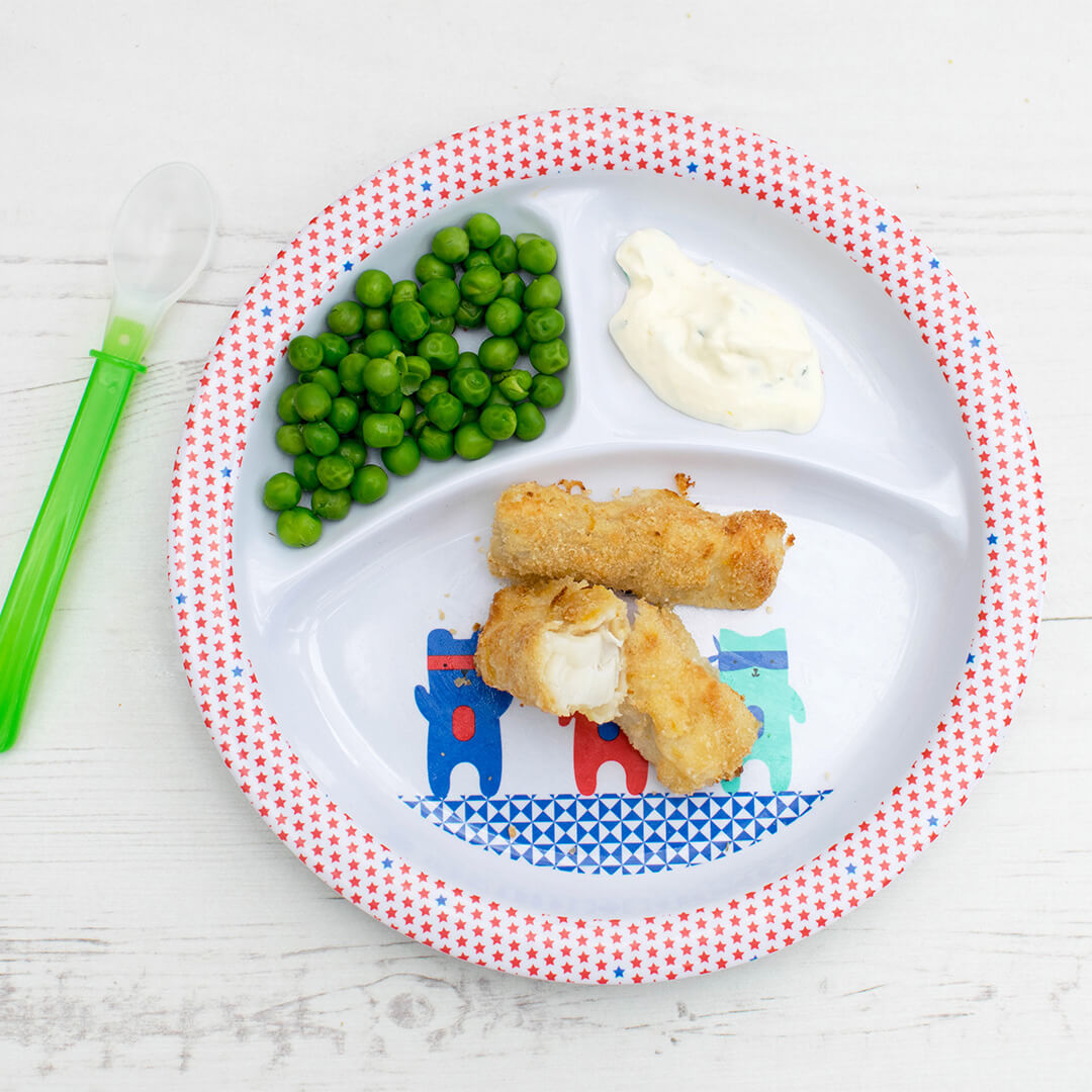 Fish fingers served with peas and a dipping sauce