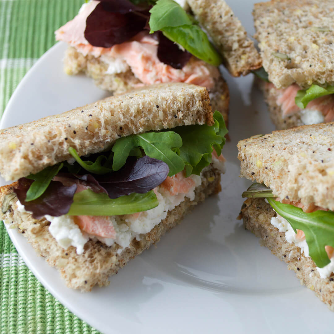 Salmon & Cream Cheese Sandwich with salad leaves cut into quarters