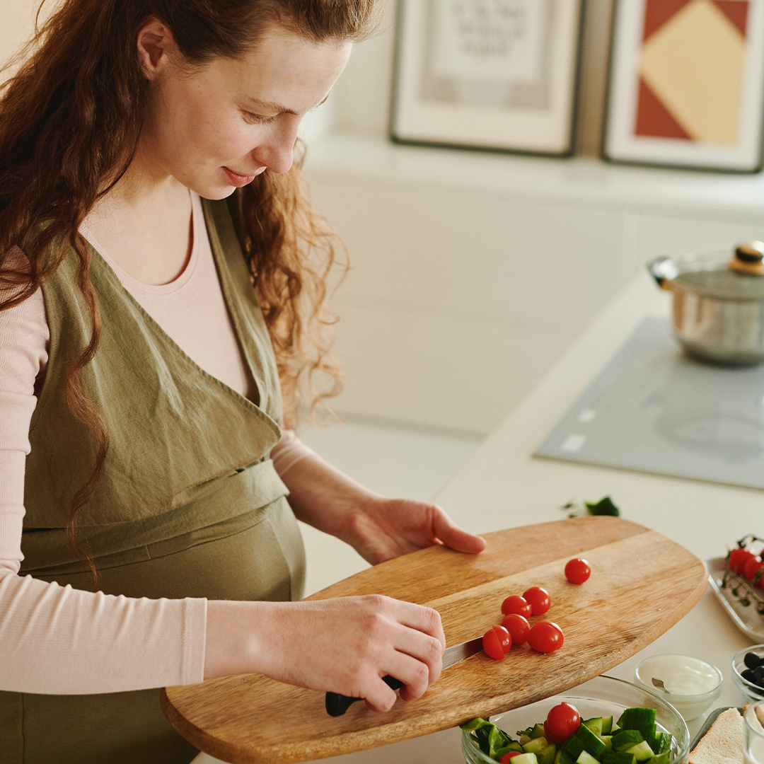Pregnant lady chopping scrumptious vegetables