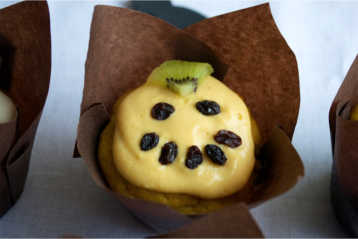 Sweet Halloween Pumpkin Muffin decorated with kiwi and raisins to look like a pumpkin