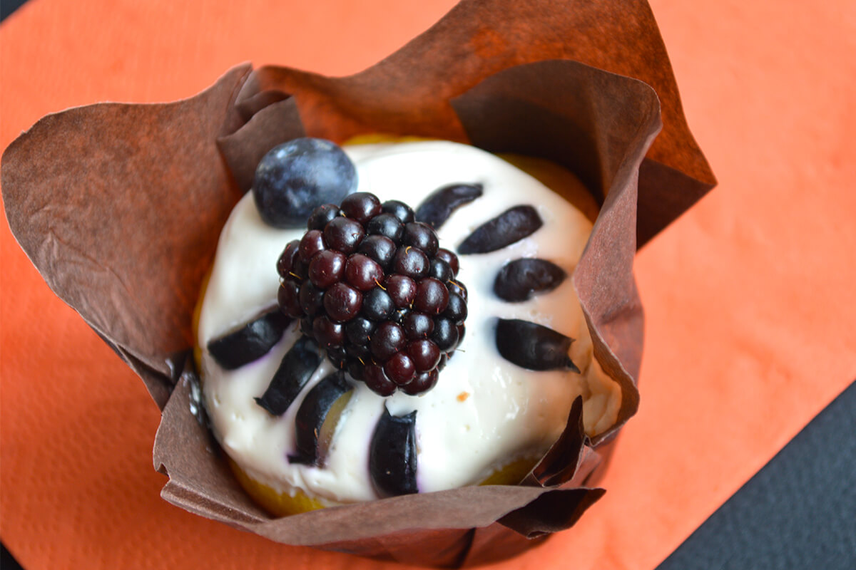 Sweet Halloween Pumpkin Muffin decorated with a blackberry body, blueberry head and sliced blueberry legs to look like a spider