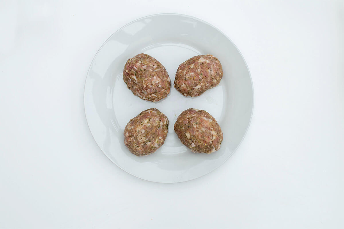 4 balls of sausage-turkey meat with eggs encased in the middle of them