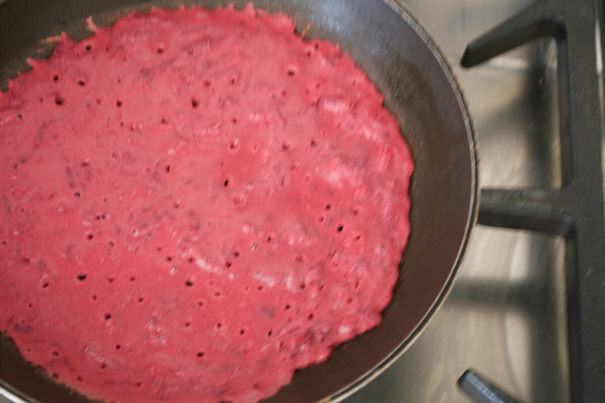 Beetroot wrap batter being cooked in frying pan