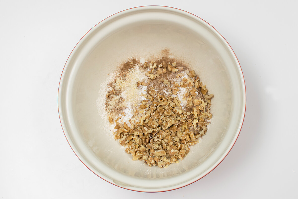 A bowl of flour, almond flour, baking powder, baking soda, cinnamon and nuts