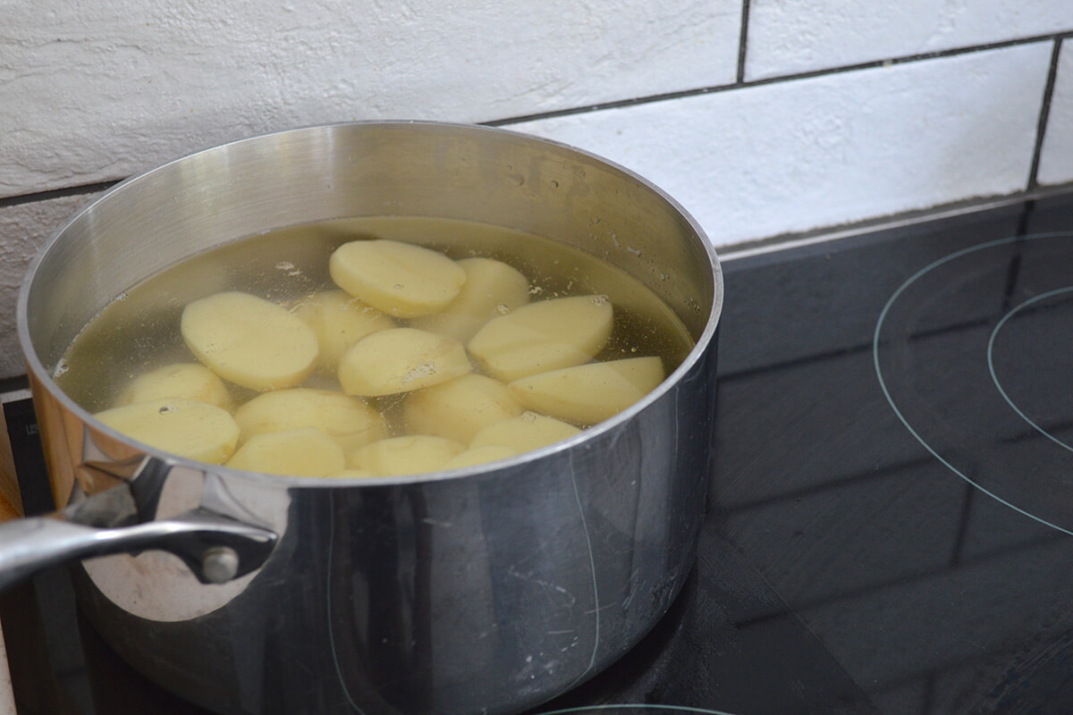 A saucepan of chopped potatoes being boiled
