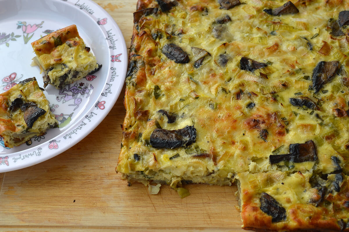 A serving of Artichoke, Mushroom & Leek Frittata next to a frittata