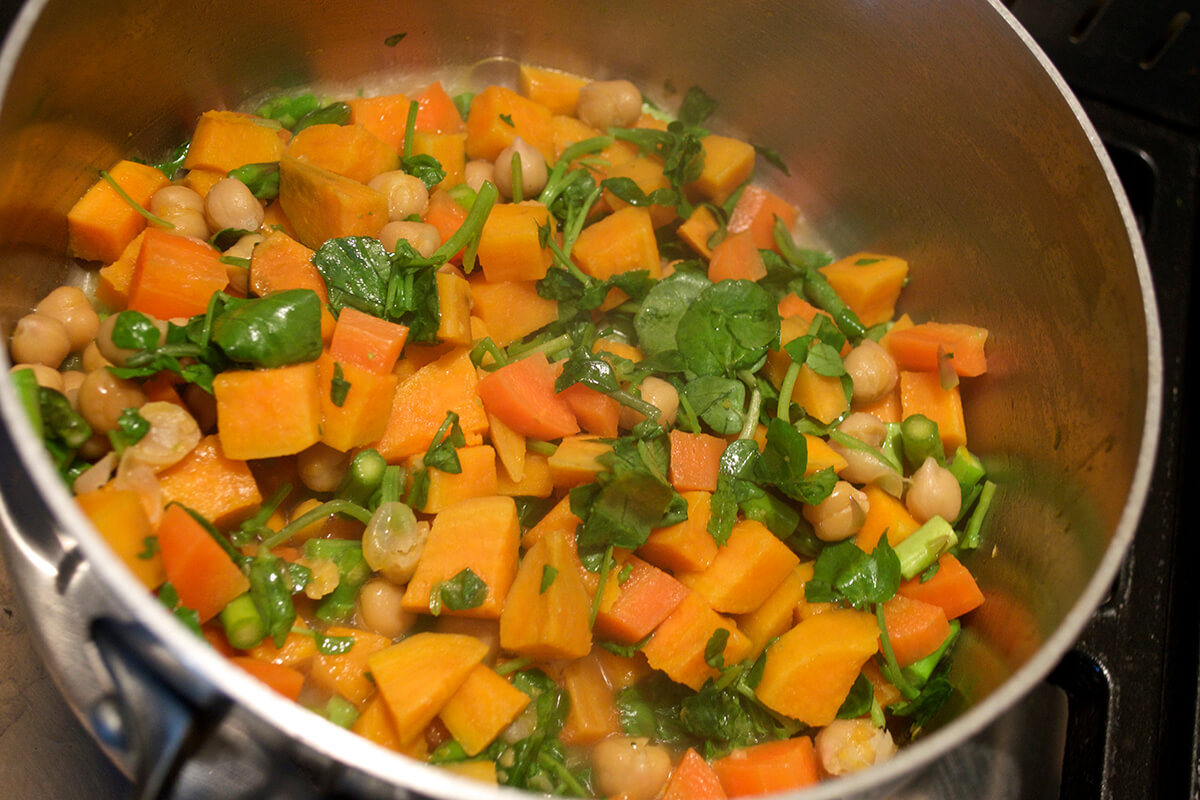 Sweet potato and carrot in a saucepan with asparagus and watercress