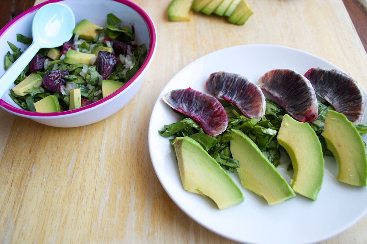 A serving of Blood Orange & Avocado Salad, next to a bowl of Blood Orange & Avocado Salad