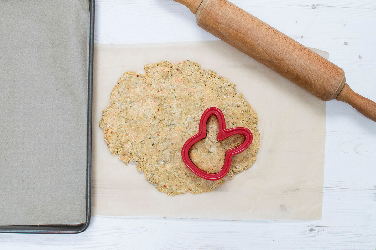 Biscuit dough being cut out with a bunny shaped cutter