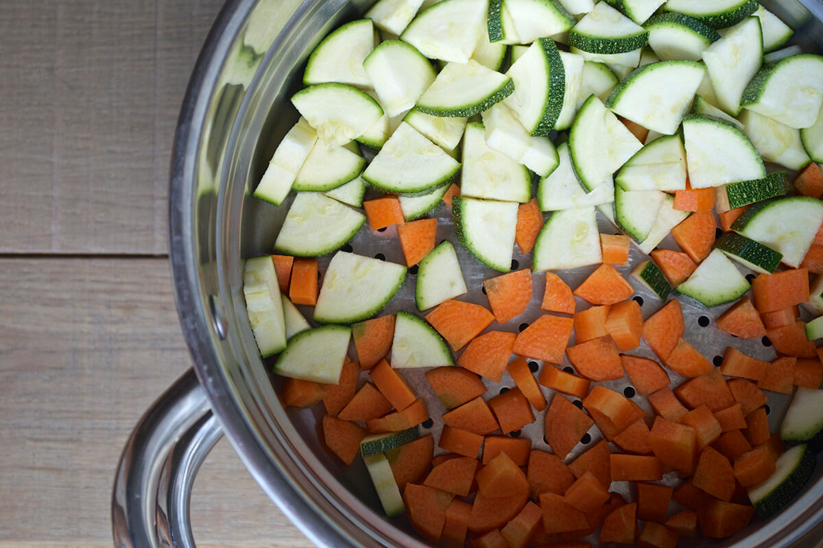 Chopped carrot and courgette in a steamer