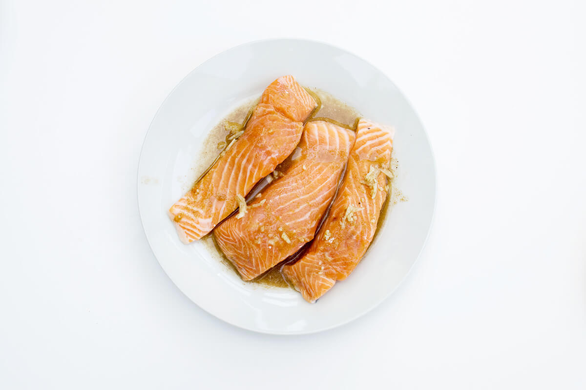 A plate of 3 salmon fillets in lime juice, ground coriander and crushed garlic
