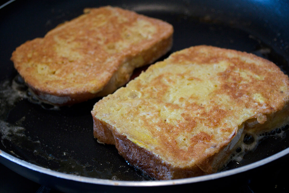 French toast being fried in frying pan