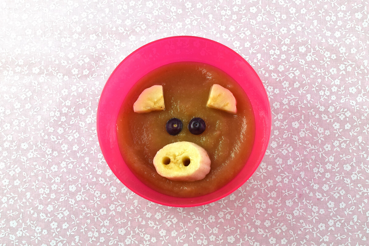Fruit puree in bowl with banana snout and ears and blueberry eyes