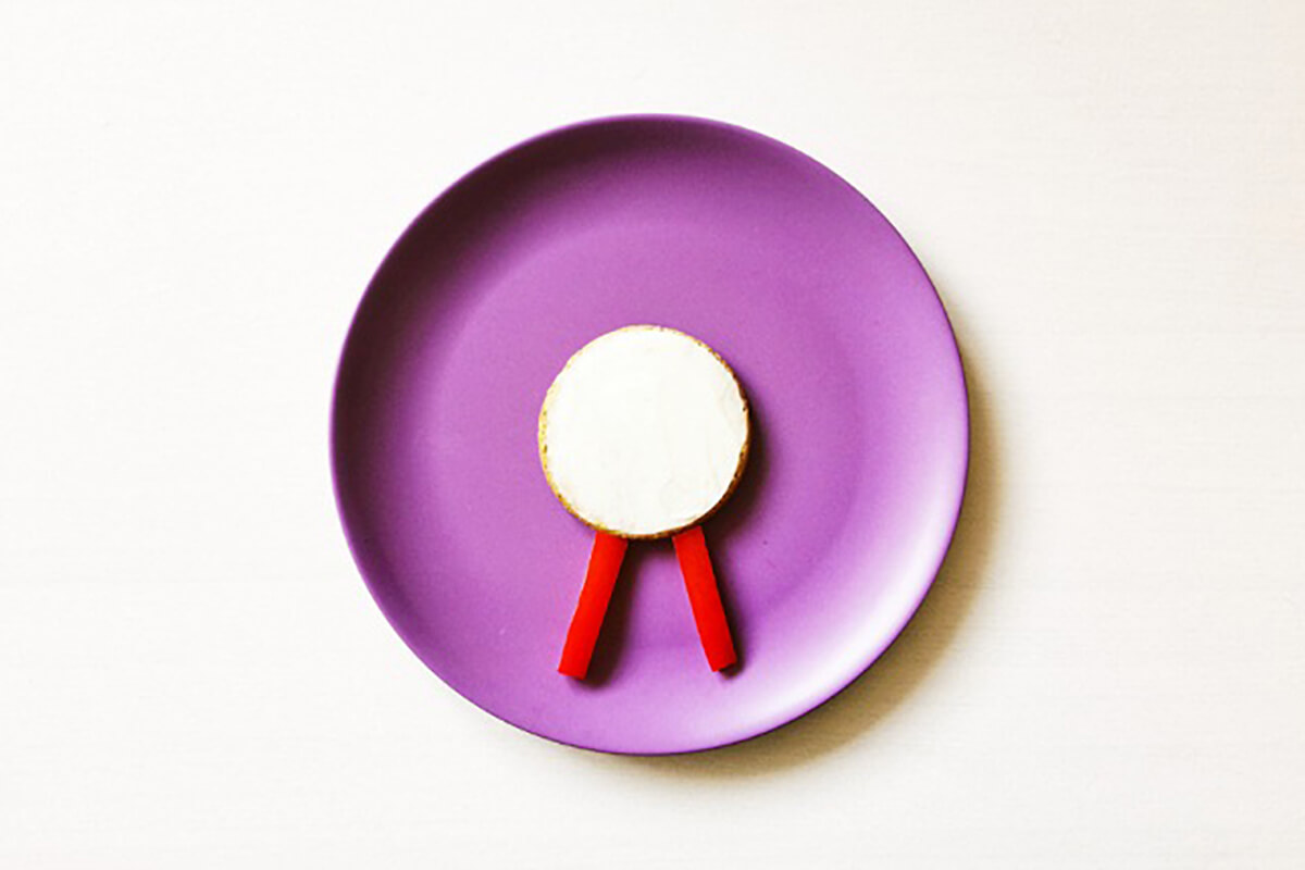 Oat cracker with two finger size slices of pepper creating legs