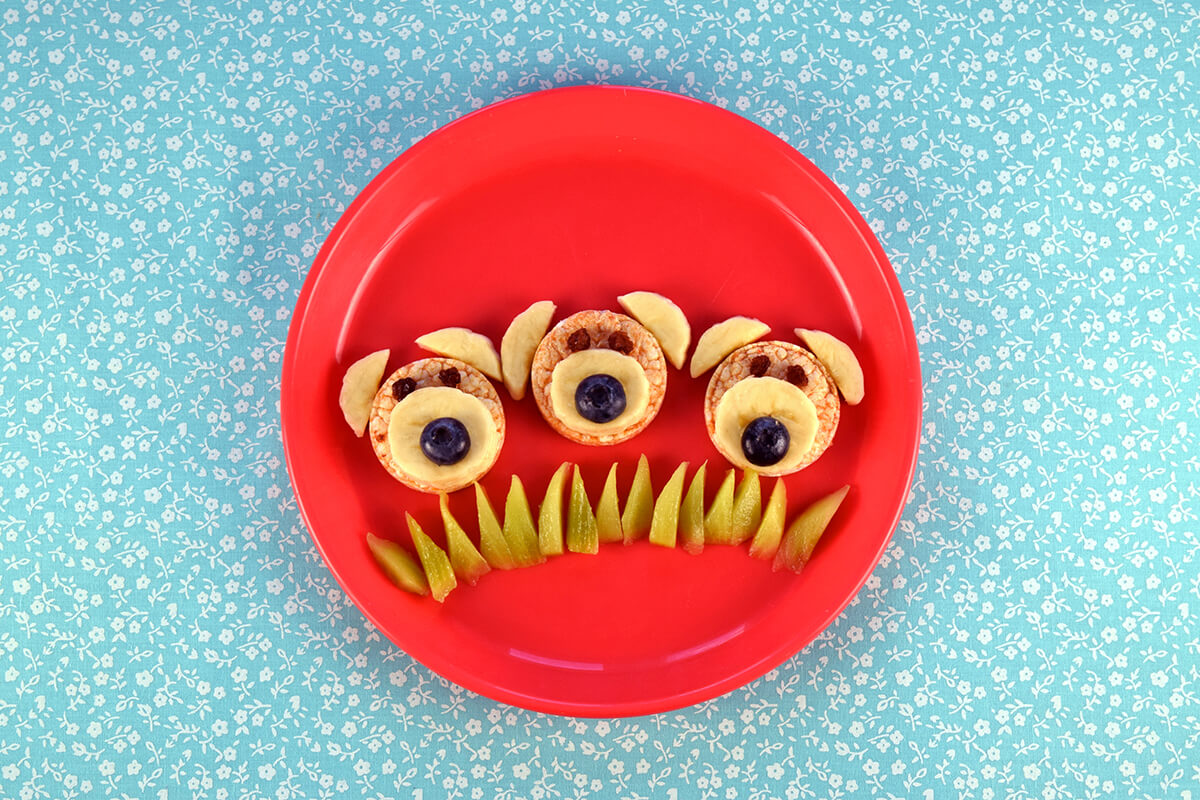 Halved blueberries are added to the centre of the banana slices to create noses