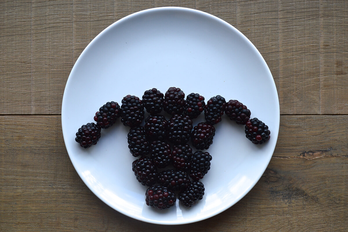Blackberries halved lengthways and arranged on plate in the shape of a sheep head