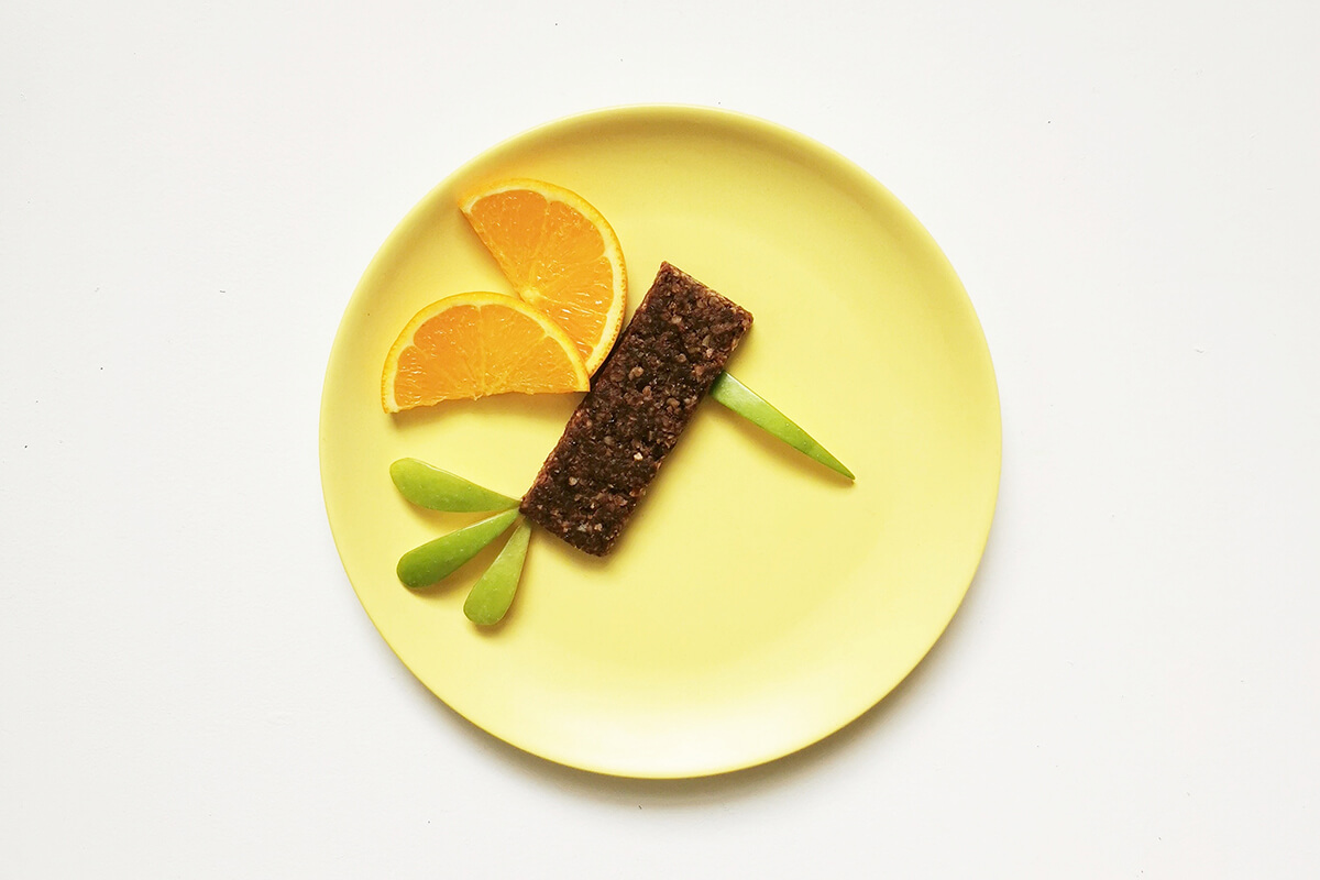 1 apple slice is arranged at the front of the oaty bar to create a beak and 3 at the bottom to create a feathered tail