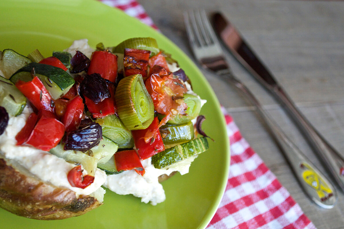 Jacket potato topped with hummus, courgette, red pepper, red onion, leek and cherry tomatoes