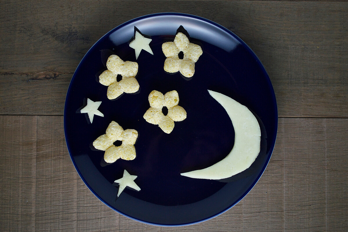 The sliced moon cheese and stars are added to the plate with the organix melty stars