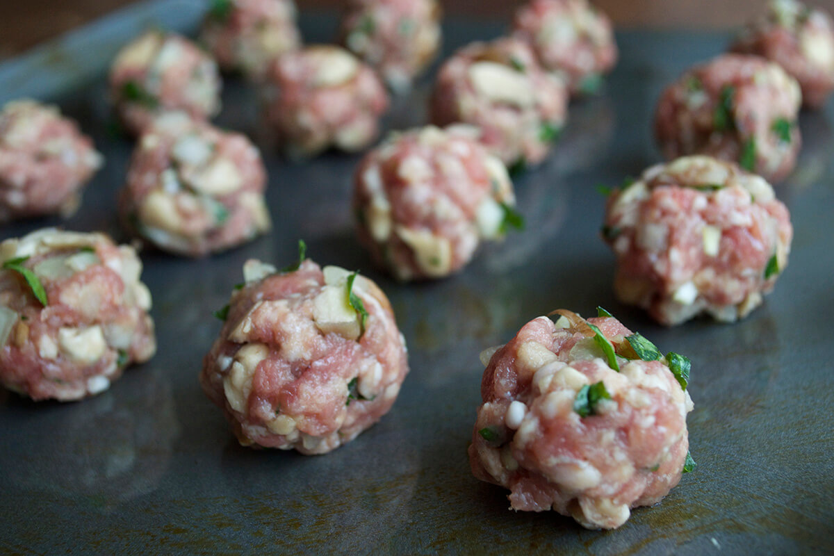 Uncooked meatballs on a baking tray