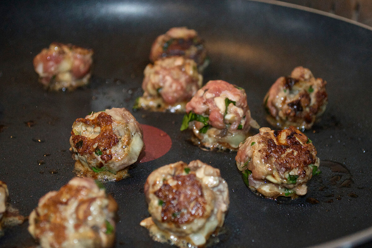 Meatballs being cooked in a frying pan