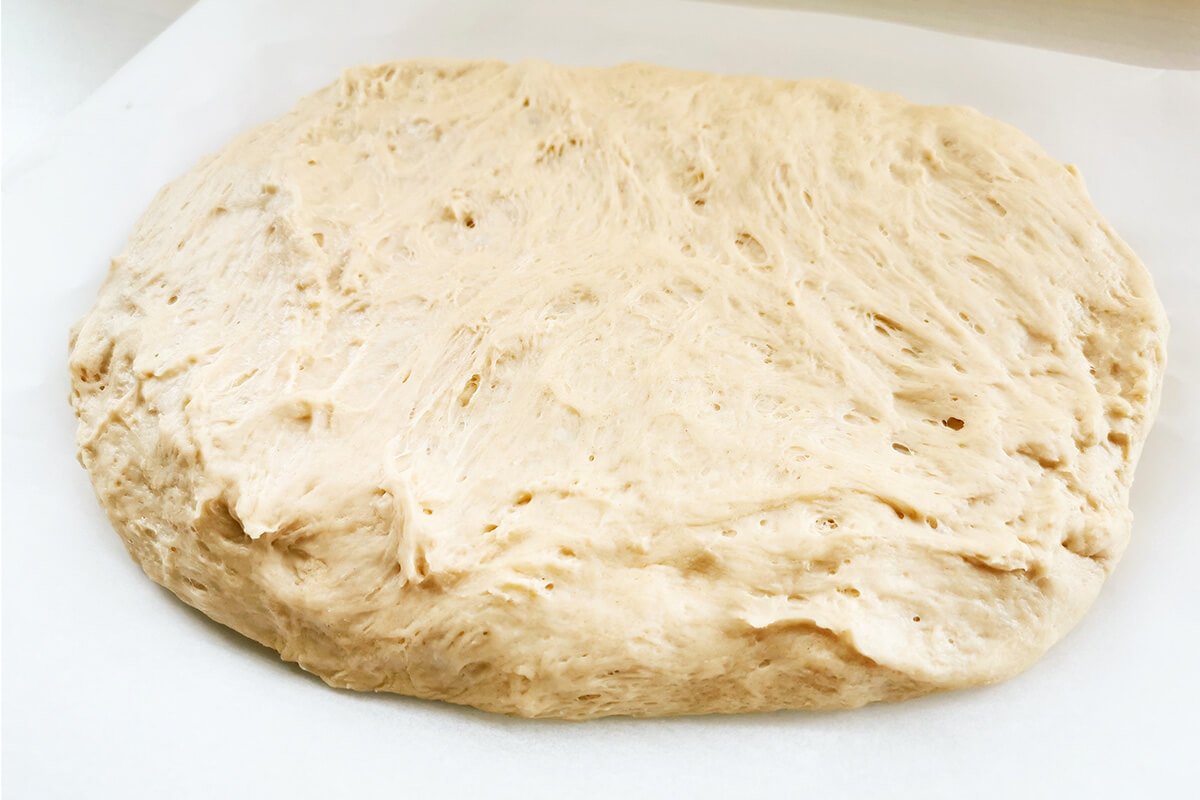 Dough stretched across a baking sheet