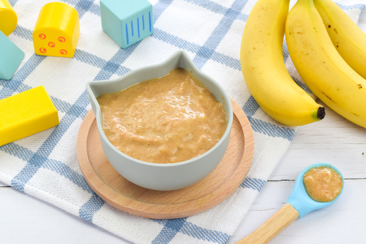 A serving of peanut butter and banana puree, next to some bananas