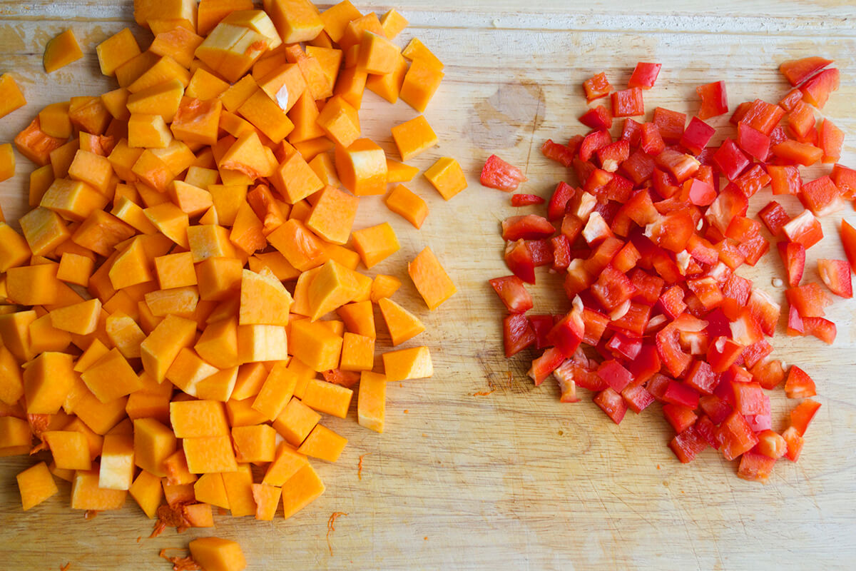 A chopping board of diced butternut squash and red pepper