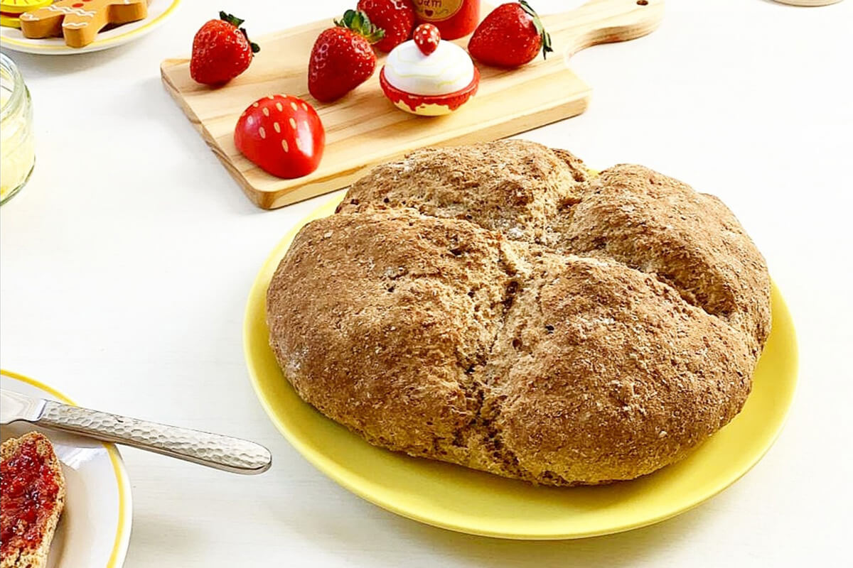 A small loaf of soda bread next to some strawberries