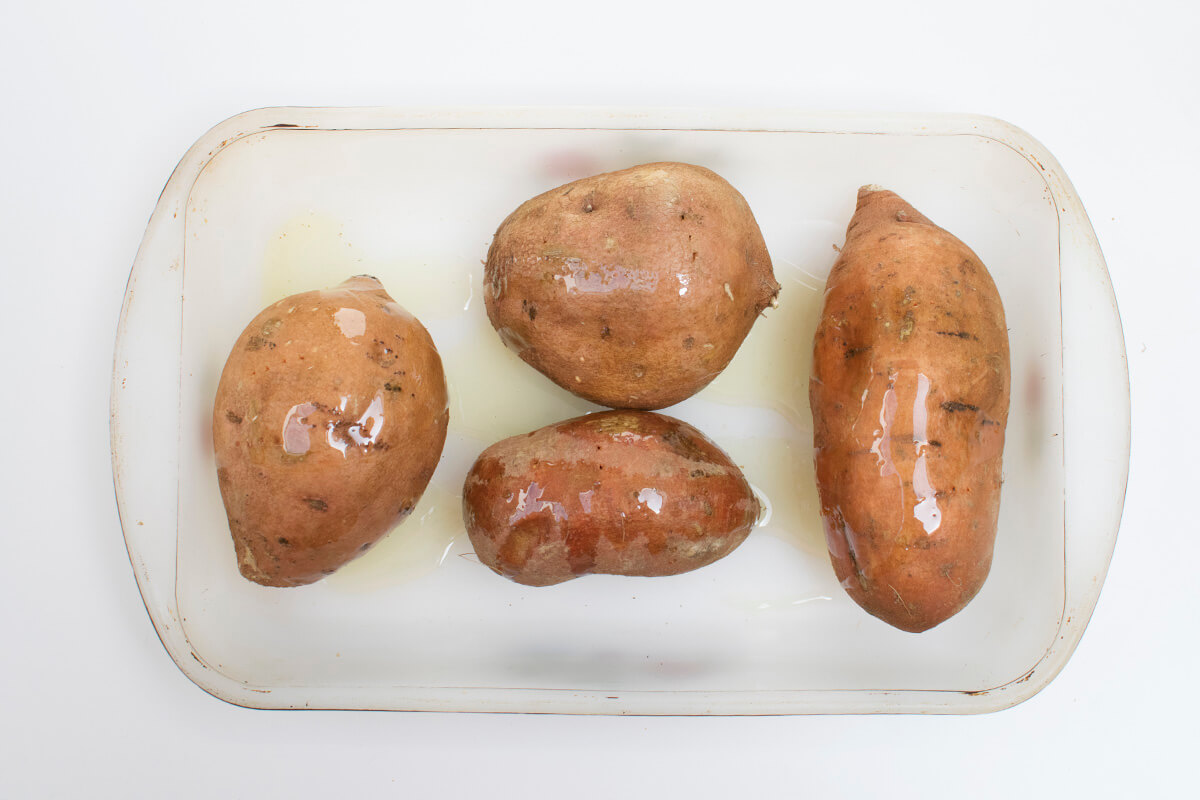 4 sweet potatoes in a glass ovenproof dish