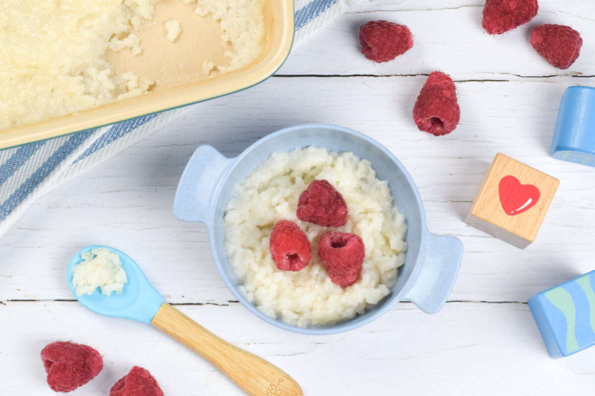 A small bowl of rice pudding topped with raspberries