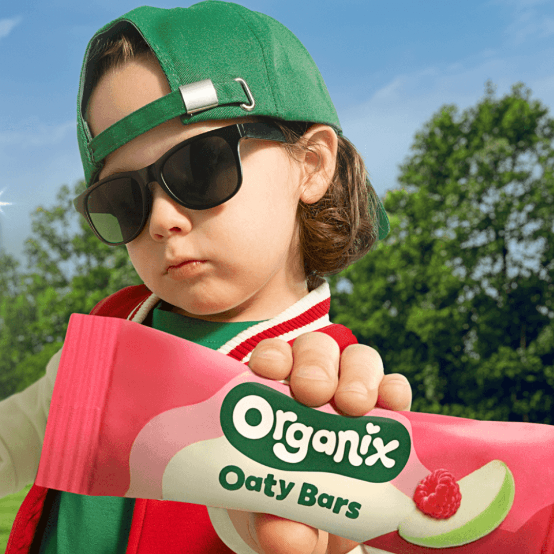 Kid holding organix apple and raspberry oaty bars